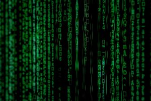 Green computer code characters cascading vertically on a black background, resembling the digital rain effect from the Matrix movie.
